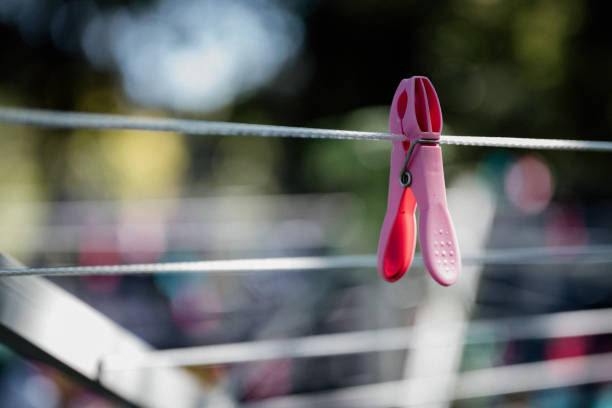 A clothing drying rack with a pink peg and blurry background