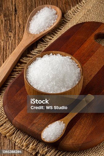 istock Coarse salt in bowl on wooden background. 1345388284