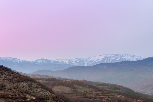 Distant snow covered Midzor summit on Old mountain during blue hour and soft, purple sky