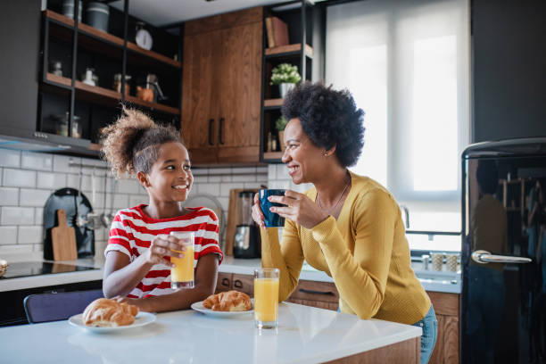 istock Mother and daughter having breakfast in the kitchen 1345390667