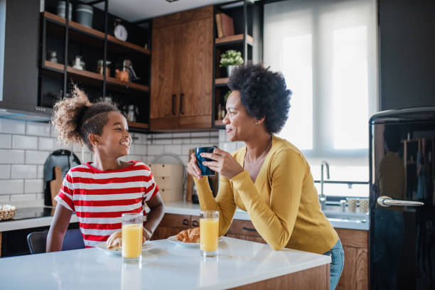 istock Mother and daughter having breakfast in the kitchen 1345390668