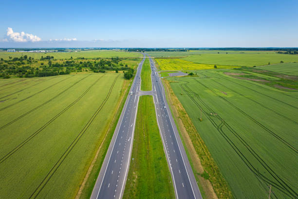 istock Asphalt highway through green summer field. Aerial view 1345392648