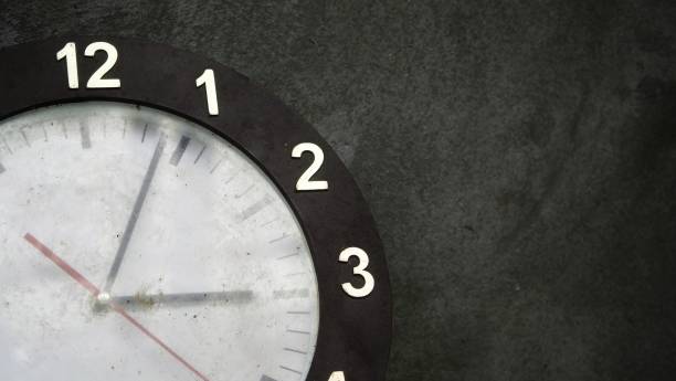 istock an abandoned wall clock with a gray cement wall as a background. 1345394849