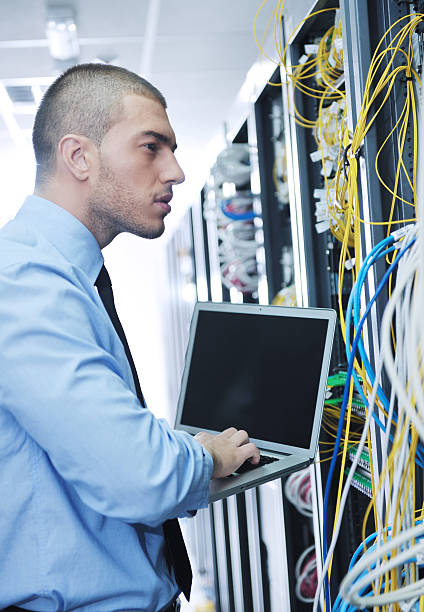 istock businessman with laptop in network server room 134540004