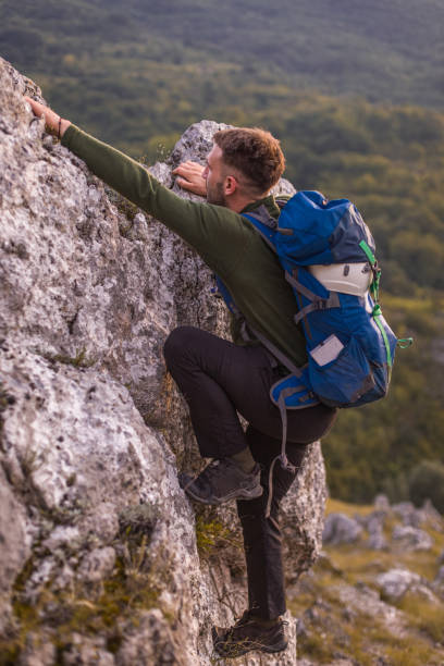 istock Success man hiker hiking on sunrise mountain peak 1345403369