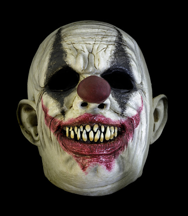 Creepy Grin Clown Mask Isolated Against Black Background