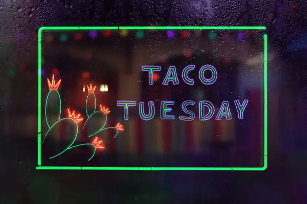 Taco Tuesday Neon Sign in Rainy Window of Mexican Restaurant