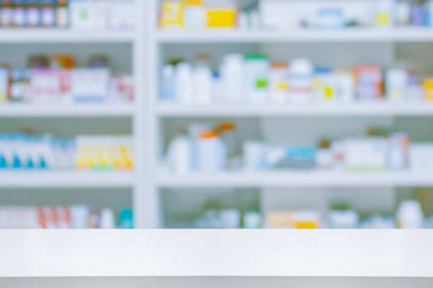 istock Empty white counter with pharmacy drugstore shelves blurred background 1345408459