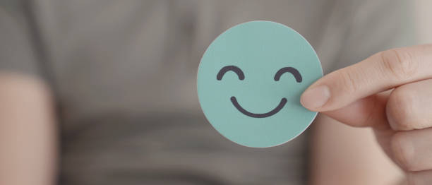 ręka trzymająca zielony szczęśliwy uśmiech twarz wycięta z papieru, ocena zdrowia psychicznego, pozytywne samopoczucie dziecka, koncepcja światowego dnia zdrowia psychicznego - comparison questionnaire test results marketing zdjęcia i obrazy z banku zdjęć