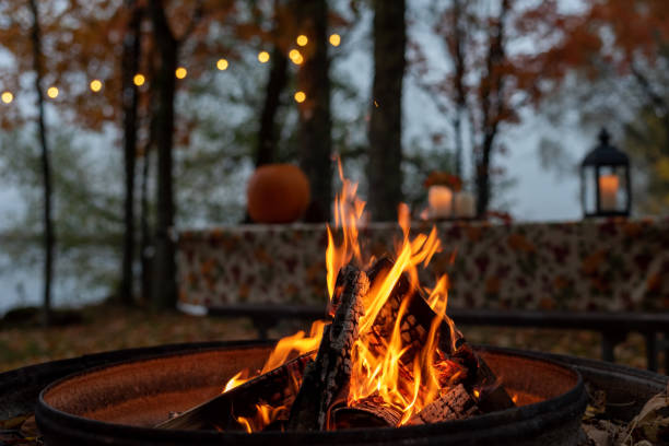 glowing campfire at autumn campsite - fotos de aconchegante imagens e fotografias de stock