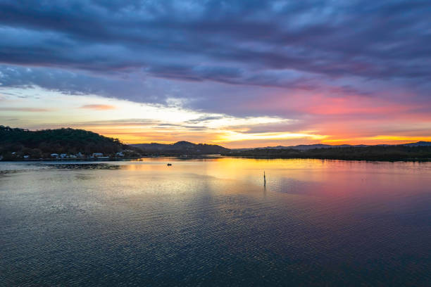istock Sunrise waterscape with colourful cloud covered sky 1345417902
