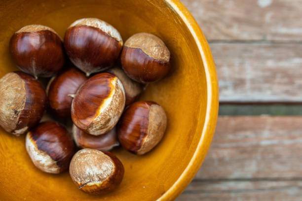 istock Fresh picked big chestnuts in wooden bowl 1345419722