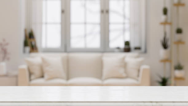 istock Empty tabletop for montage over blurred modern comfortable white living room background 1345423645