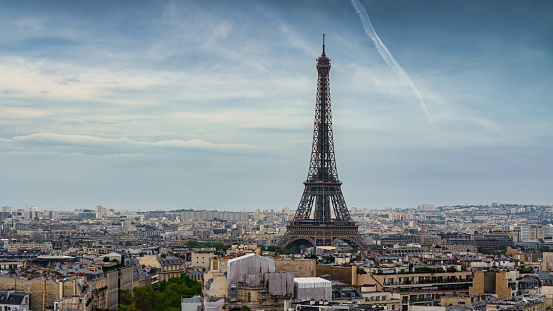 Eiffel Tower in Paris under blue summer skyscape. Aerial Panorama Cityscape view over the Paris with the iconic Eiffel Tower in the City Center at Champ de Mars, 7th Arrondissement, Paris, France, Europe