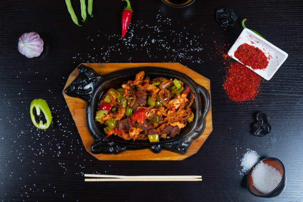 istock Chopped fried meat mixed with vegetables on frying pan 1345431540
