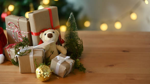 istock Christmas presents and teddy bear laid on a wooden table. 1345434270