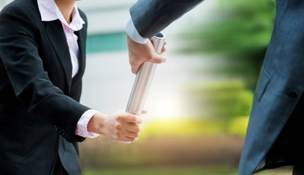 Business people pass the baton outdoors stock photo