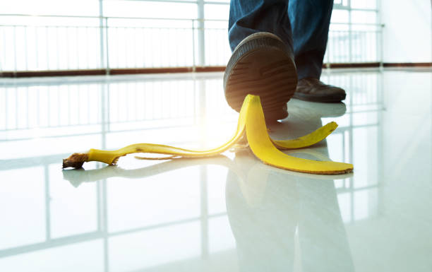 businessman stepping on banana peel - wrong injury imagens e fotografias de stock