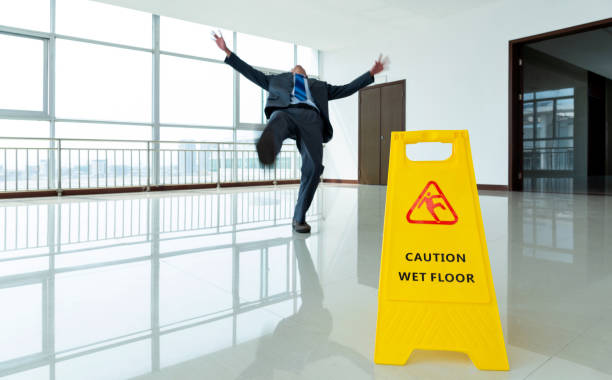 uomo d'affari che scivola dal segnale di avvertimento - floor wet slippery danger foto e immagini stock