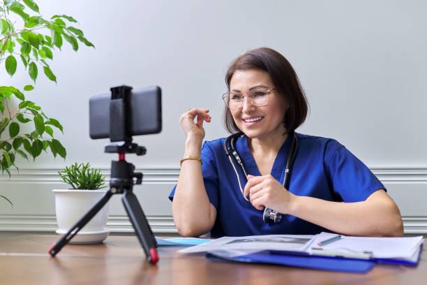istock Female doctor with a stethoscope consulting online using a smartphone on a tripod 1345438464