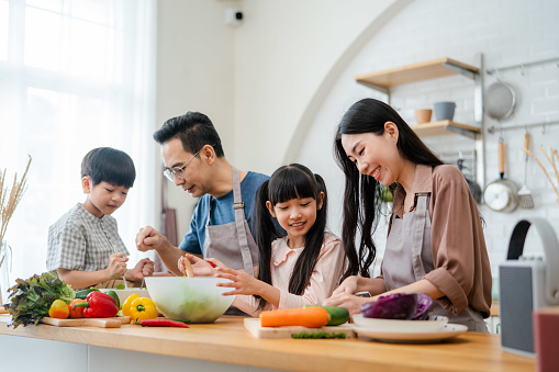 Asian family making together a lunch in kitchen on  holiday at home.