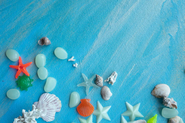istock Seashells summer background. Many different seashells, starfish on a background of turquoise paint strokes. Place for text with border at the bottom edge 1345443141