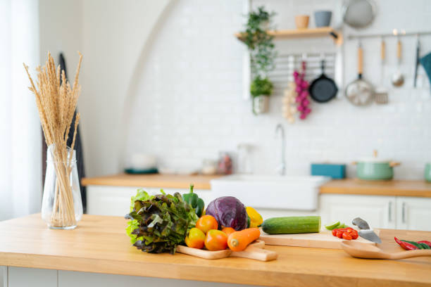 istock Kitchen table with vegetables and cutting board for preparing salad . 1345445200