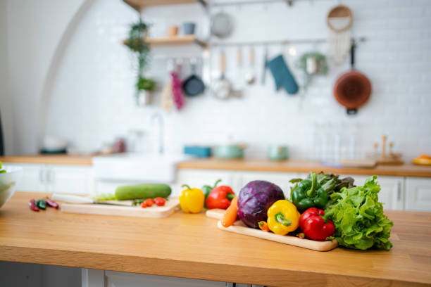 küchentisch mit gemüse und schneidebrett für die zubereitung von salat. - rustic domestic kitchen canning vegetable stock-fotos und bilder