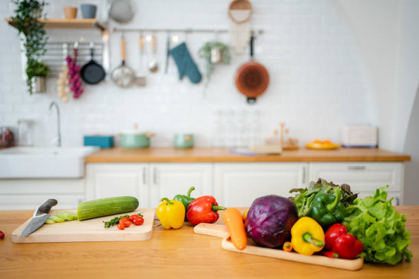 istock Kitchen table with vegetables and cutting board for preparing salad . 1345445212
