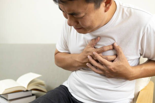 彼の胸に触れるアジアの中年男性, 窒息と胸の痛みと圧迫感, 心臓や喘息発作の病気の男性患者, 息切れや呼吸とパニック病の問題, 呼吸器 - senior male ストックフォトと画像