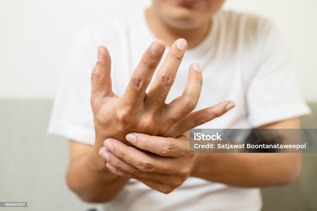 Close up,asian middle-aged man with shaking of Parkinson's disease,symptom of resting tremor,male patient holding her hand to control hands tremor,neurological disorders,brain problems,health care Hand Stock Photo