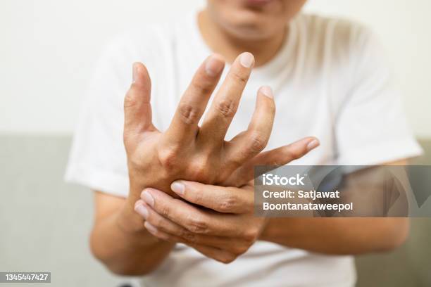 Close Upasian Middleaged Man With Shaking Of Parkinsons Diseasesymptom Of Resting Tremormale Patient Holding Her Hand To Control Hands Tremorneurological Disordersbrain Problemshealth Care Stock Photo - Download Image Now