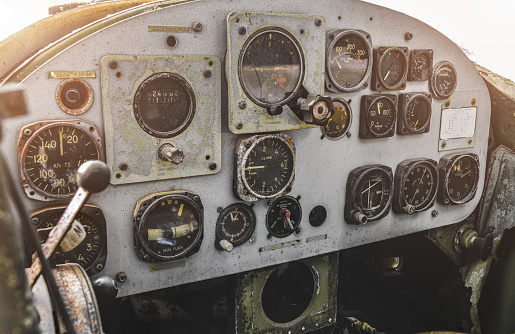 Damaged old war military helicopter control panel cabin with low lighting.