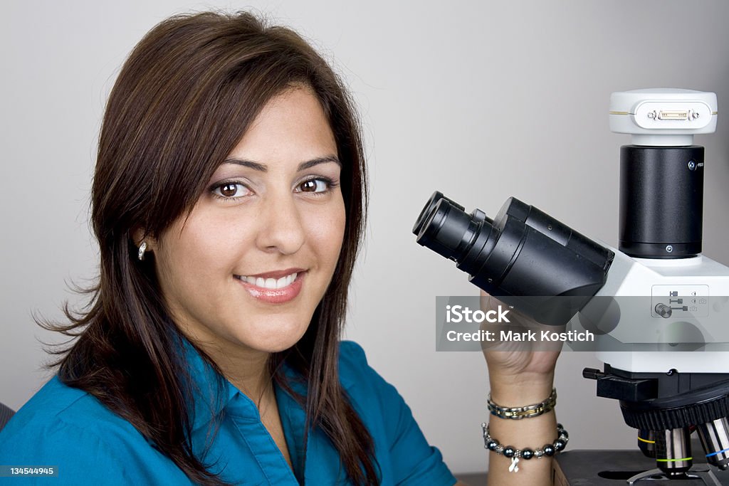 Schöne Hispanic Student auf der Suche durch Mikroskop - Lizenzfrei Bildkomposition und Technik Stock-Foto