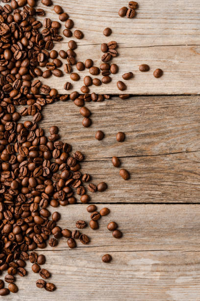 istock Coffee beans on an old wooden table. 1345449699