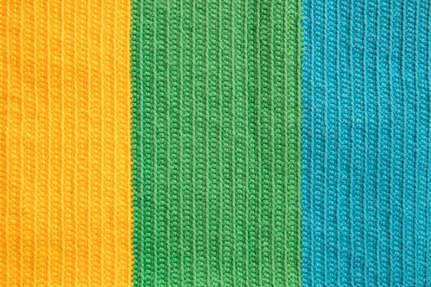 Eye-pleasing crochet pattern in three different soft colors yarn: yellow, green and blue cotton thread, symmetrical background created by the continuous half double stitches as handicraft inspiration.