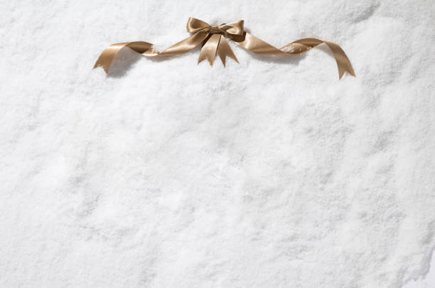Gold satin tied bow on snow texture background