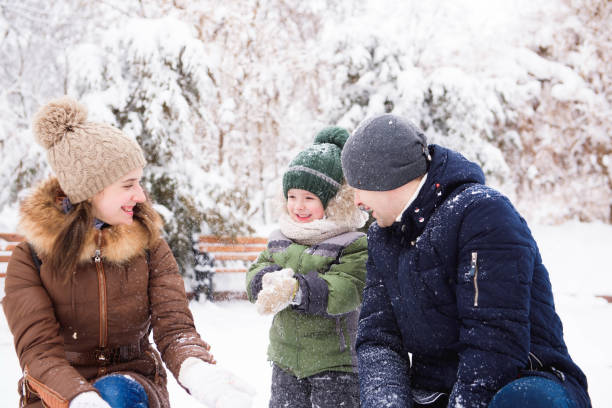 istock happy family having fun and playing with snow in forest 1345451408