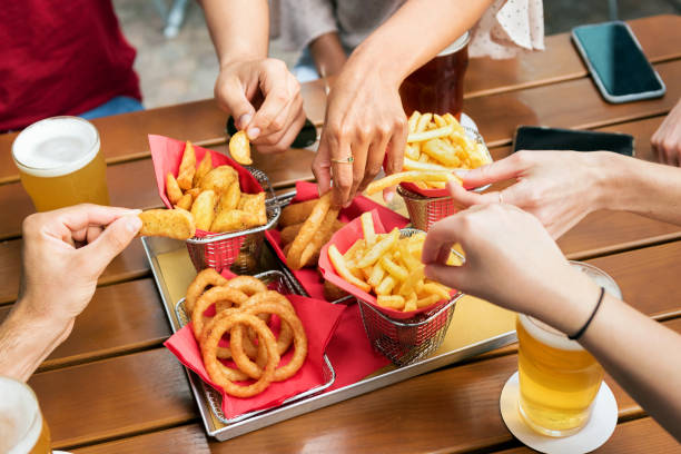 istock Friends eating fries in pub 1345453054