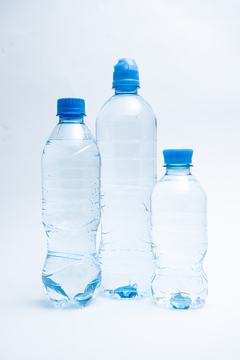 Various bottles of pure still water on white background