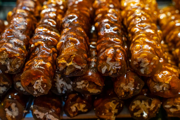 Cevizli sucuk made by dipping a string with walnuts into a grape molasses mixture, the sweet sucuk is then hung out to dry and cut into pieces and enjoyed as a gummi-like dessert.