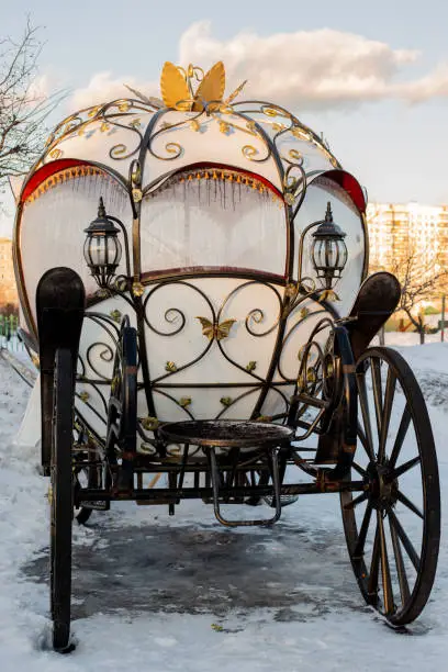 Photo of The white carriage with wrought iron elements is in the snow