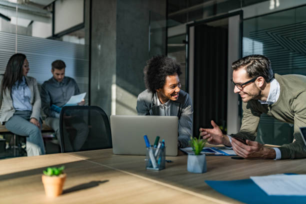 istock Happy business colleagues talking while working at casual office. 1345455744