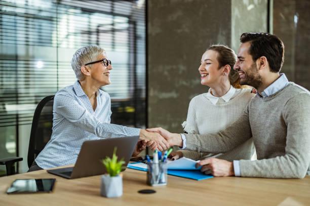 happy couple came to an agreement with their agent in the office. - finance senior adult financial advisor meeting imagens e fotografias de stock