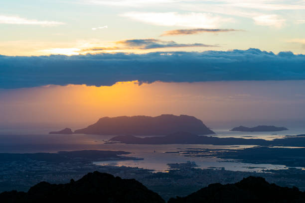 view from above, stunning sunrise during a cloudy day with the city of olbia, the homonymous gulf and tavolara island in the distance. panoramic view from monte pino, sardinia, italy. - city of sunrise bay mountain peak cloud imagens e fotografias de stock