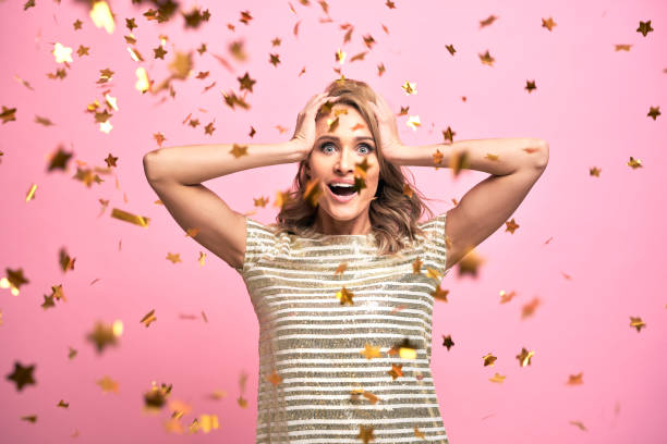 istock Blonde woman have fun with gold confetti 1345456070