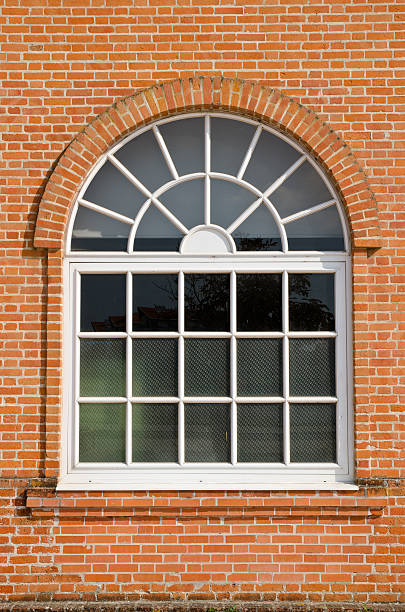 istock White painted wood arched window in brick wall 134545859