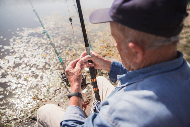 Rear view of an elderly man fixing his fishing rod