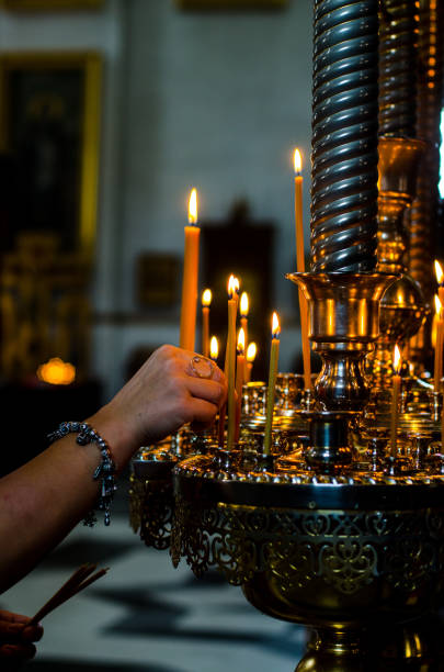Putting candle inside of Svyatohirska Lavra
