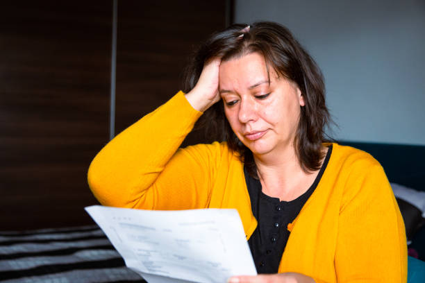istock Worried woman checking bills at home 1345466792